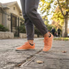 Mujer lifestyle deportivo Forestep naranjo barefoot — zapatilla barefoot outdoor naranjo en uso exterior Chile