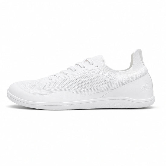 Perfil zapatilla deportiva minimalista blanca, suela plana.