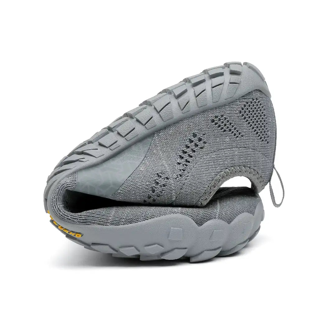 Saguaro Smart I grises dobladas demostrando flexibilidad natural barefoot.