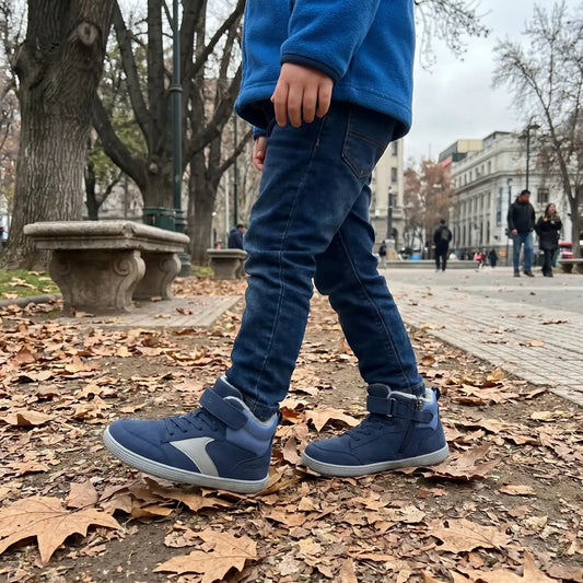 Niño caminando en una plaza usando zapatillas anchas infantiles Saguaro color azul.