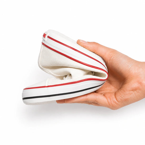 Zapatillas ergonómicas blancas Saguaro Roam I, calzado barefoot elástico doblado por completo mostrando su suela flexible drop cero en Chile.