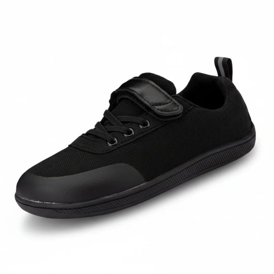 Zapato escolar barefoot negro para niño con puntera reforzada y suela flexible.